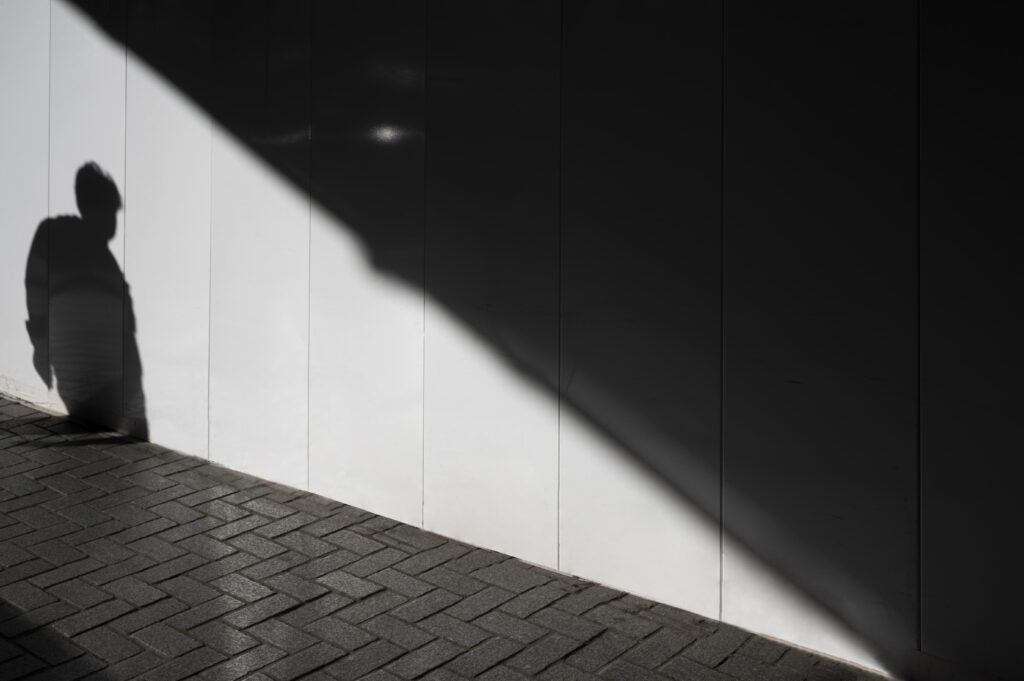 One person standing alone in a dim hallway, reflecting emotional neglect and loneliness in marriage