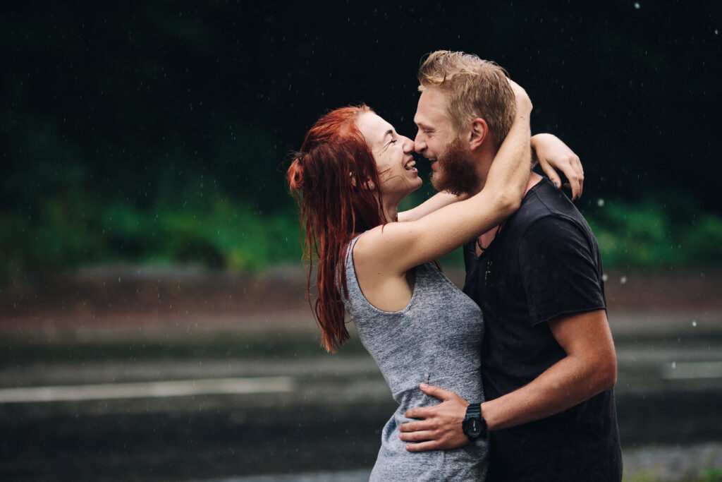 Couple hugging during a rainy day, symbolizing weathering emotional storms together