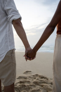 Married couple sharing subtle daily affection by touching hands as they pass