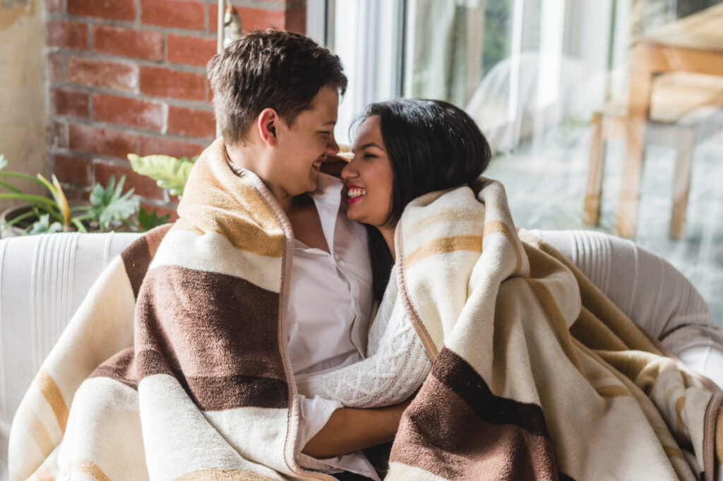 Married couple cuddling on the couch, showing emotional closeness through small acts of love