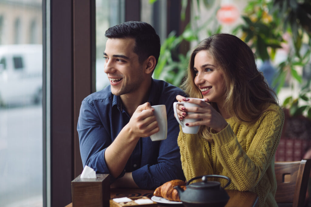 Married couple talking over coffee, building connection through consistent and open communication