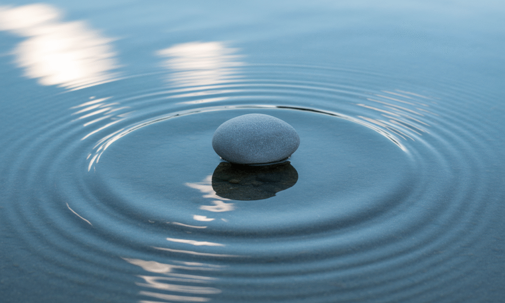 A single pebble making ripples in a still pond, symbolizing how small personal shifts can affect the whole marriage