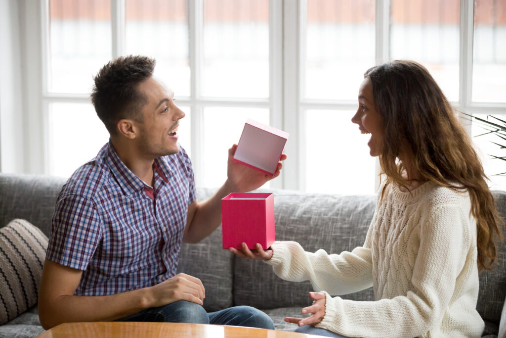 Spouse giving a handwritten card to their partner, representing everyday acts of emotional appreciation