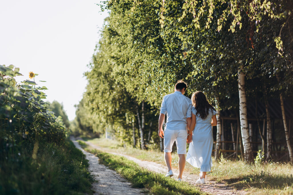 Couple walking hand-in-hand down a nature trail, symbolizing unity and forward movement in marriage