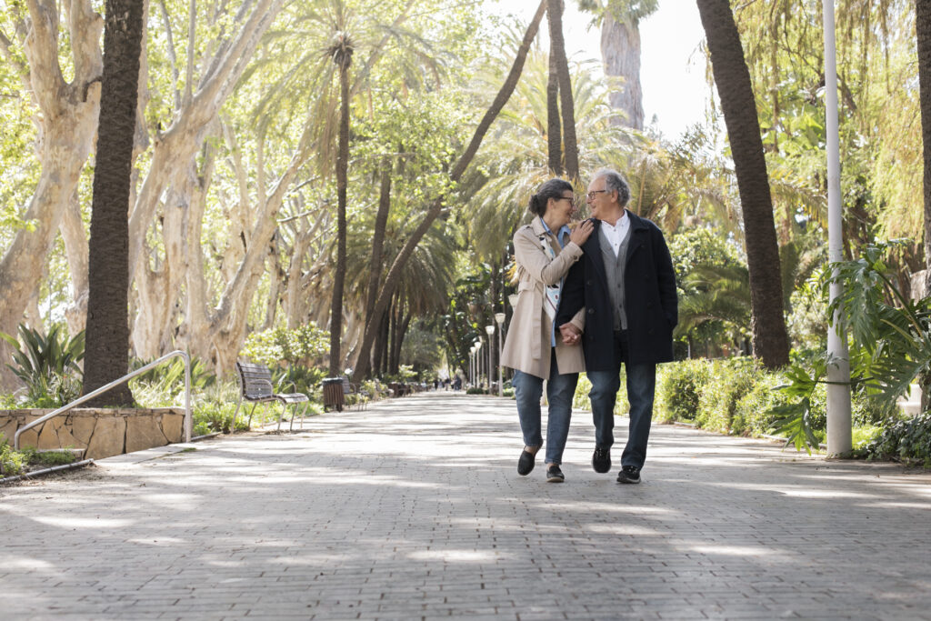 Elderly couple walking hand-in-hand, showing decades of loyal partnership