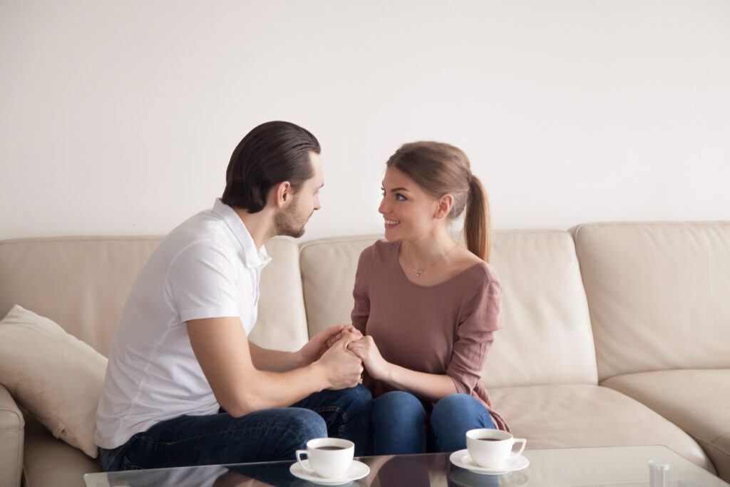 Husband and wife sitting close and talking gently, showing affection and empathy.