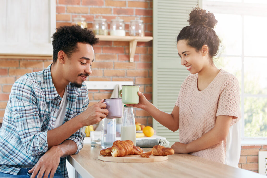 Husband and wife laughing together over coffee, illustrating the joy of emotional intimacy built over time