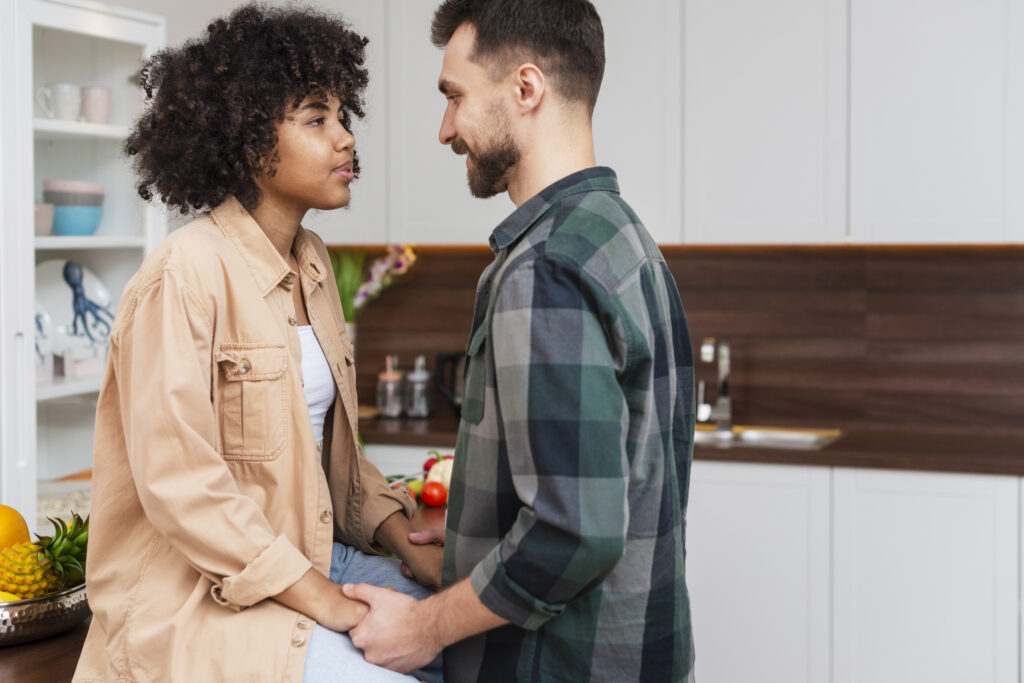 Married couple sitting together holding hands, showing emotional connection and commitment during a tough conversation