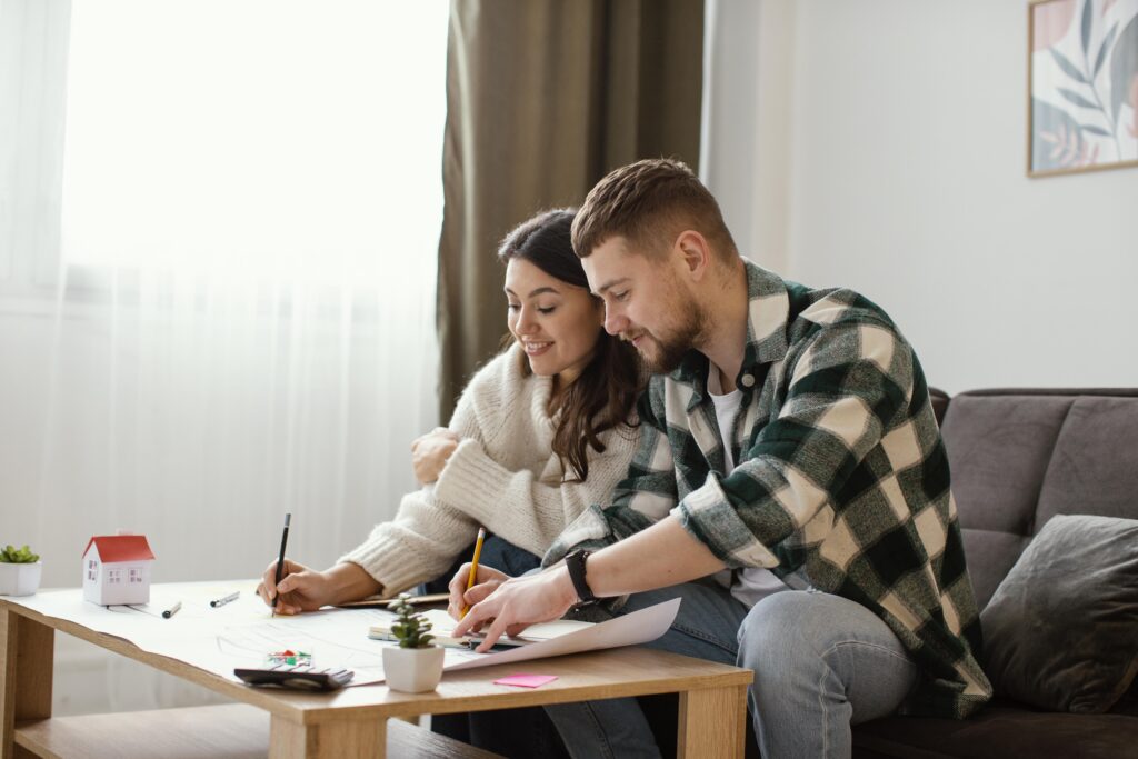 Interfaith couple journaling during a quiet spiritual discussion in their living room