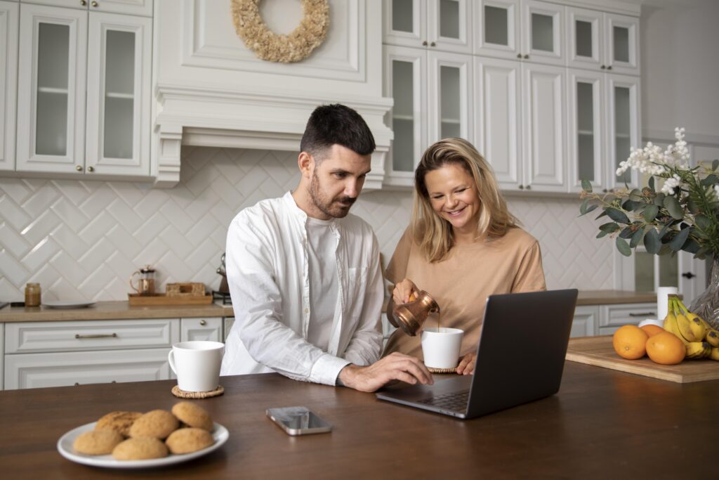 Husband and wife reviewing household budget and financial goals on a laptop