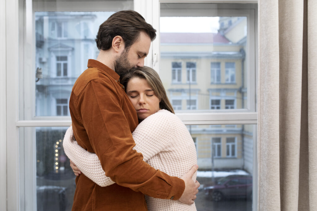 Spouses holding each other close after a hard moment, showing healing and connection built through shared struggle