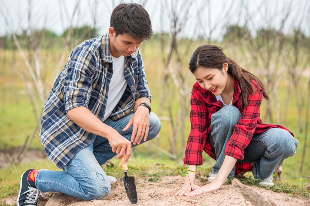 Married couple planting a tree together, symbolizing long-term investment and nurturing growth in marriage