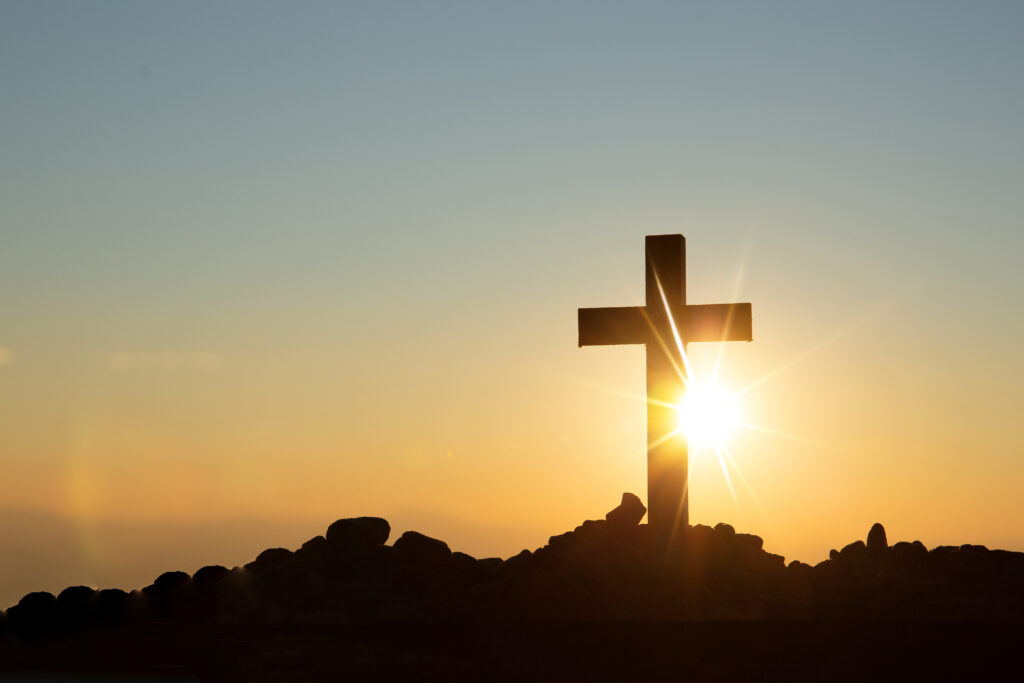 Cross on a hilltop at sunrise representing identity in Christ