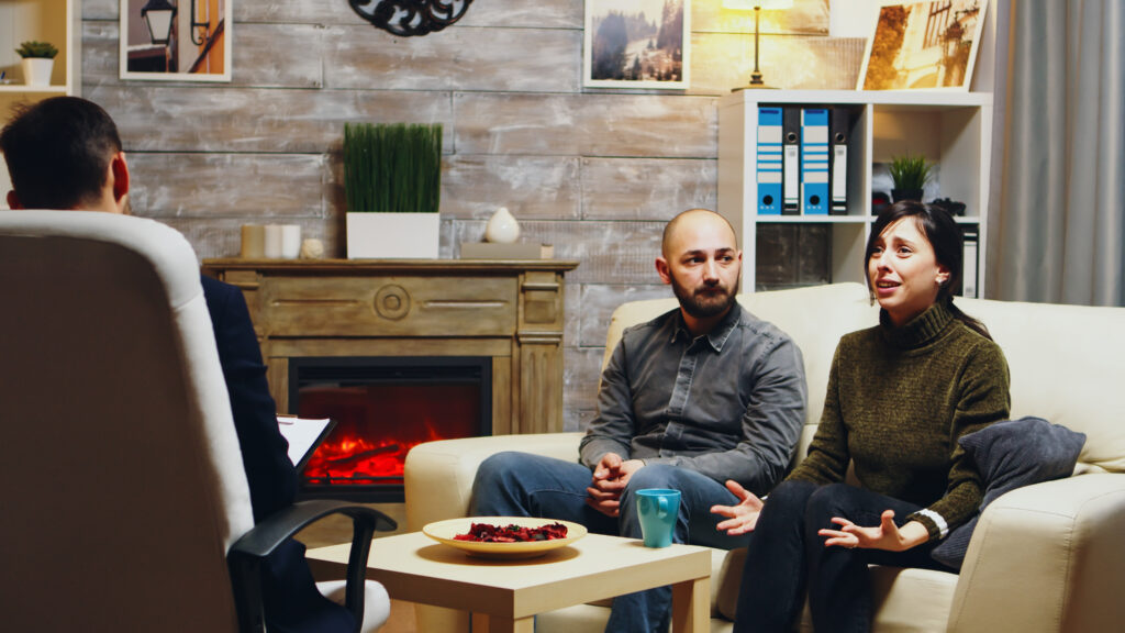 Marriage counseling session in progress, couple working through conflict with professional guidance