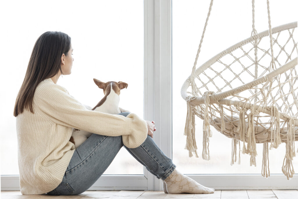 Woman reflecting alone by a window, seeking clarity in her emotions