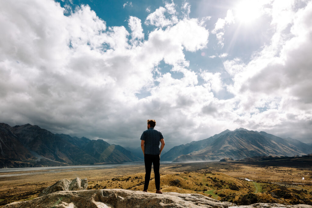 Lone hiker standing on mountaintop, representing personal completeness and strength in solitude