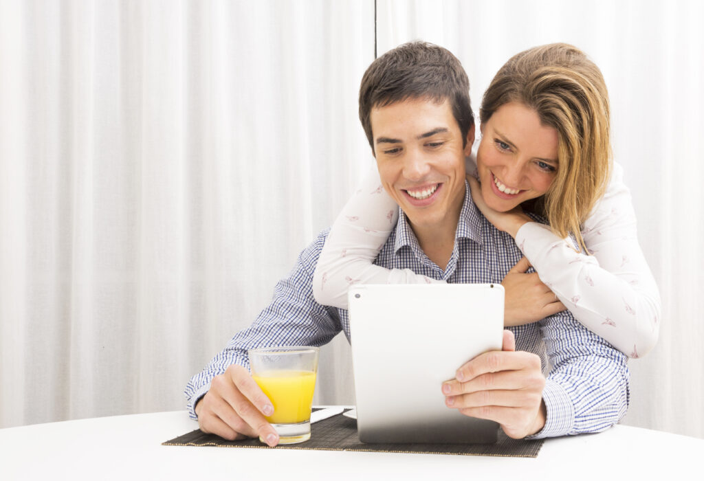 "Married couple reviewing finances together at a table, smiling and feeling unified.