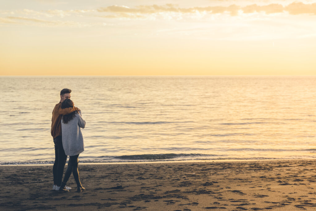 Husband and wife embracing during a sunset walk, representing unity and love.