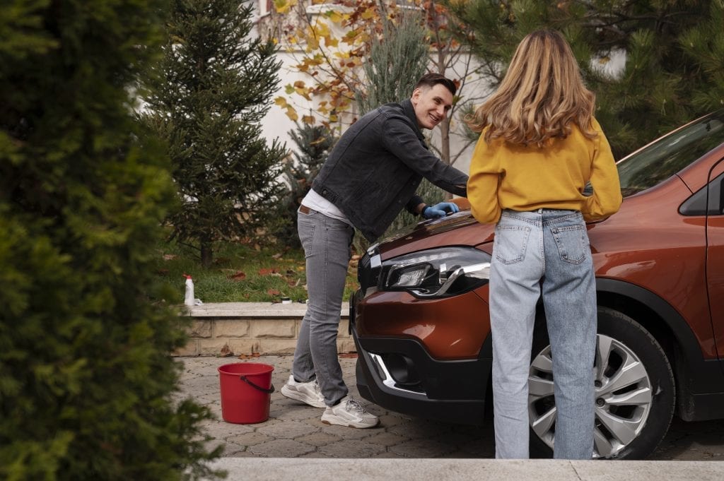Married couple washing a vintage car, symbolizing relationship maintenance
