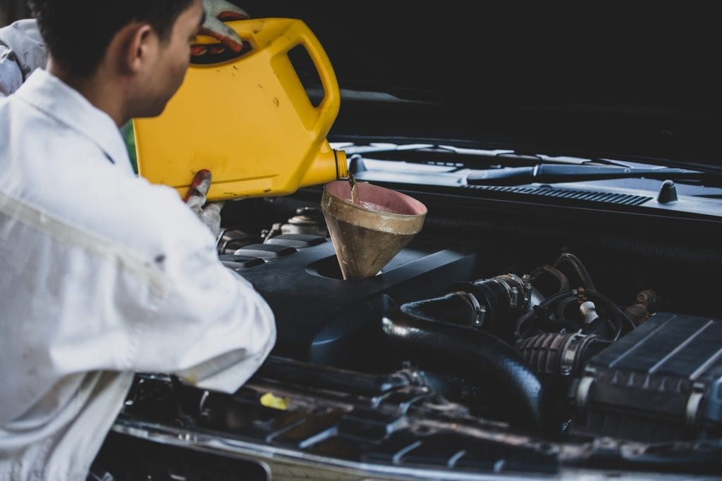 Mechanic performing oil change, symbolizing consistent care needed in marriage