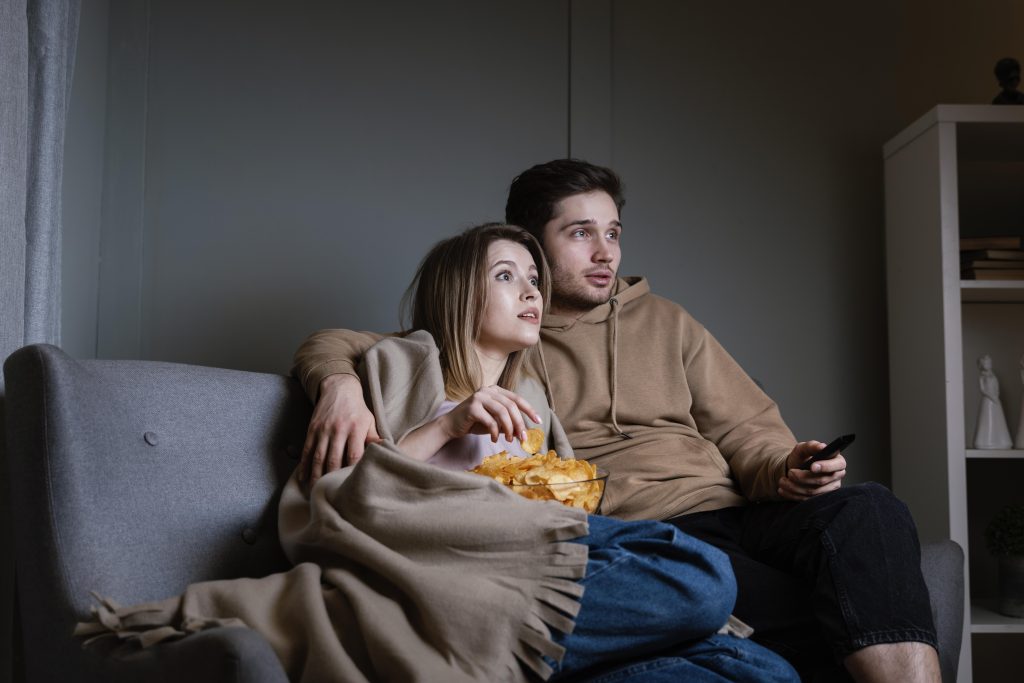 Husband and wife bonding during a cozy movie night at home