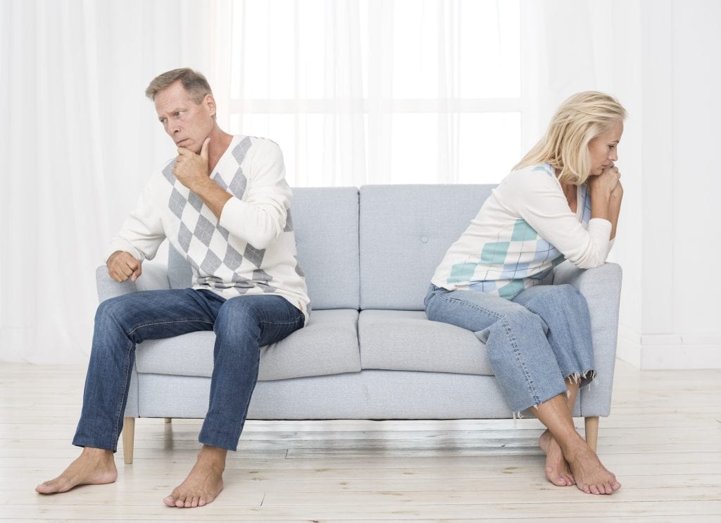 Distant couple sitting in silence, symbolizing emotional disconnection in marriage 