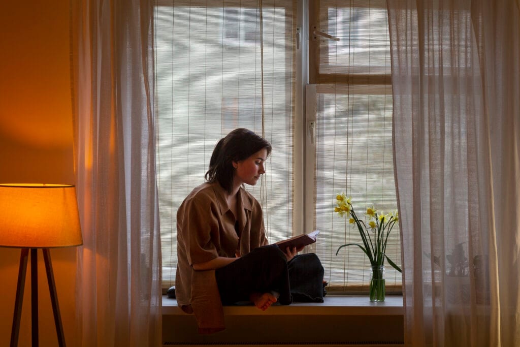 Spouse journaling by the window, reflecting on personal growth in marriage