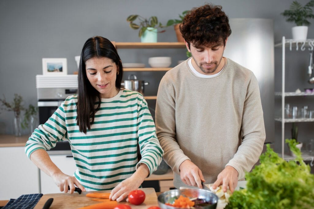 Cross-cultural couple preparing dinner together and discussing shared responsibilities
