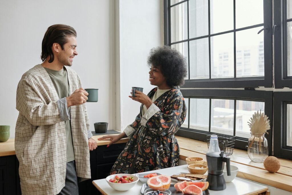 Couple laughing together over coffee in the morning.