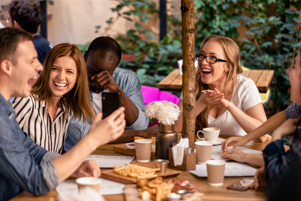 Two married couples sharing a joyful meal outdoors, deepening friendship and faith