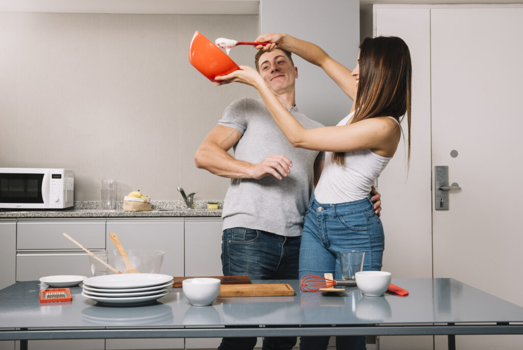 pouses sharing laughter and joy during a fun, intentional kitchen date night