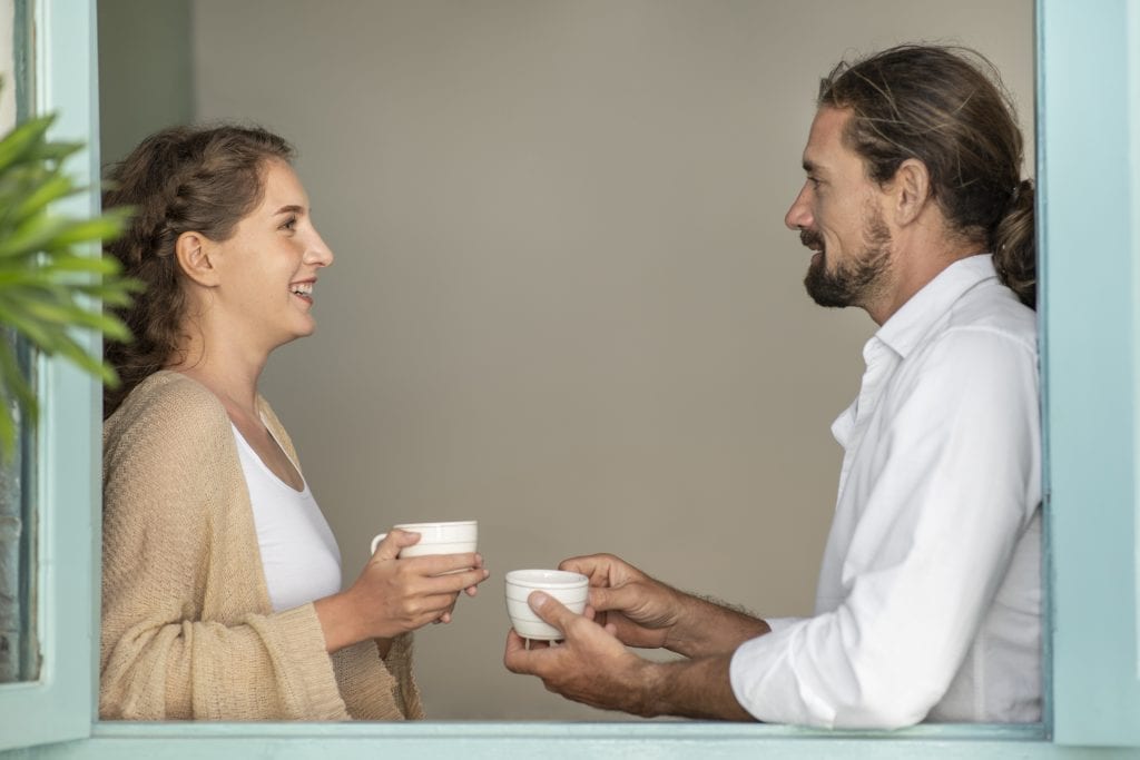 Married couple engaging in honest conversation over coffee, rebuilding trust