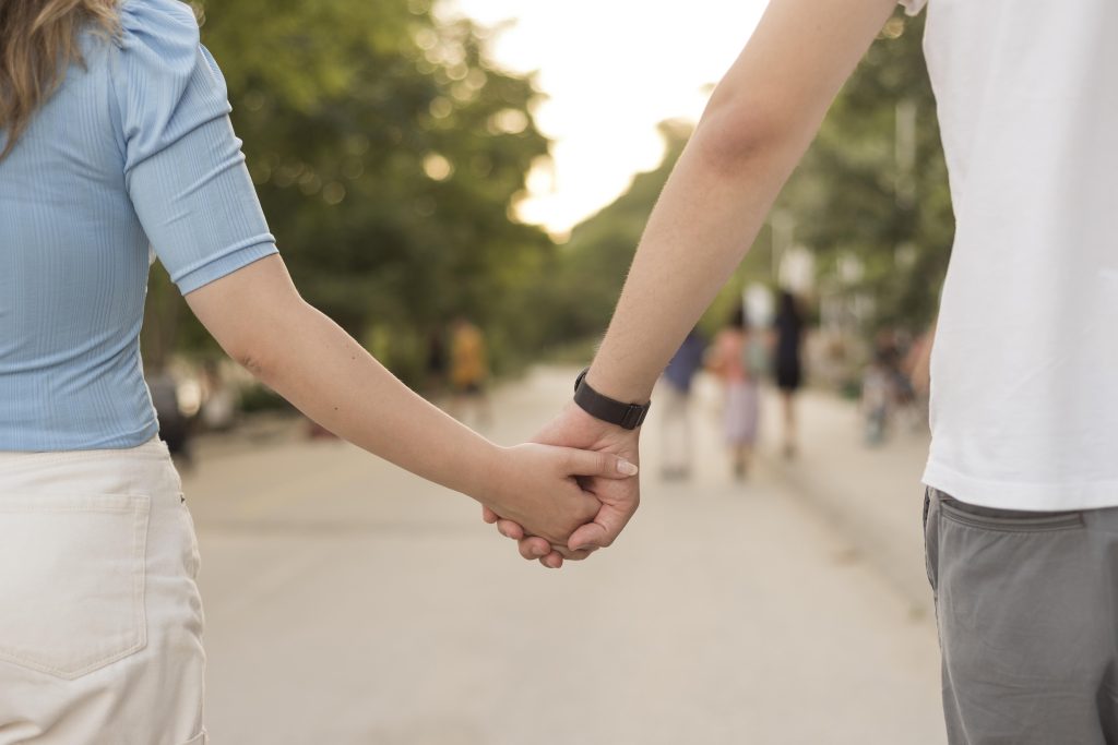 Married couple holding hands during a peaceful walk, reflecting steady love and growth