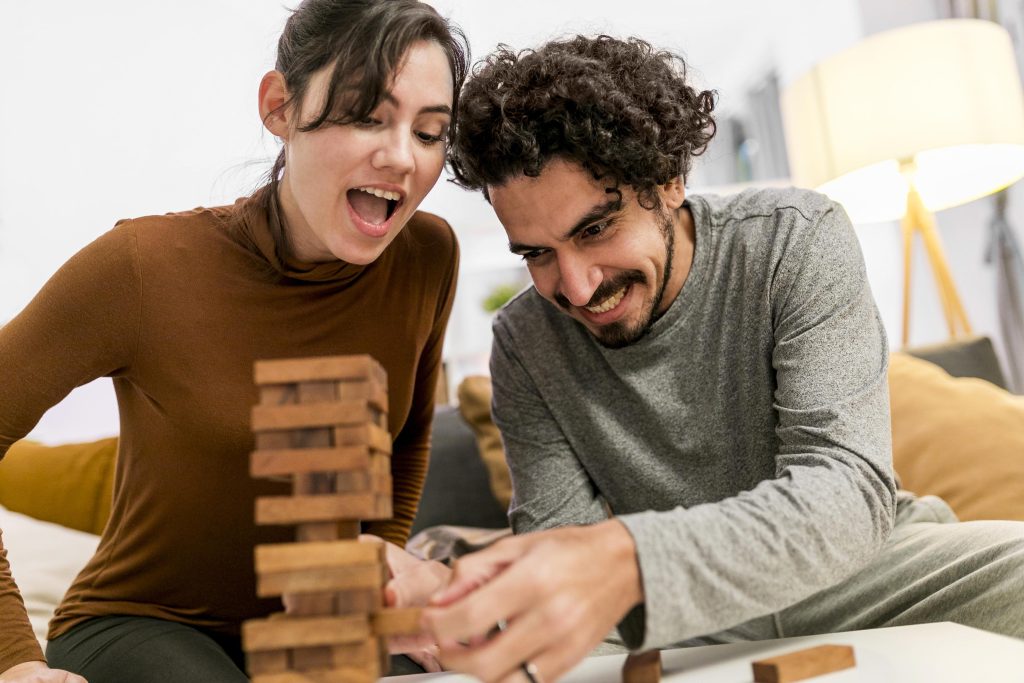 Spouses laughing together during a fun moment, celebrating the strengths in their relationship