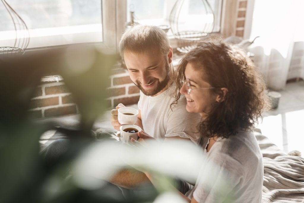 Married couple enjoying morning coffee together, reconnecting without phones.