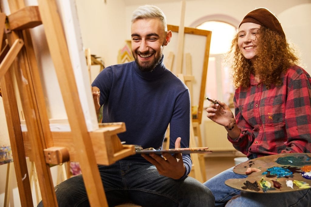 Married couple painting and laughing, representing creativity as a tool to revitalize marriage
