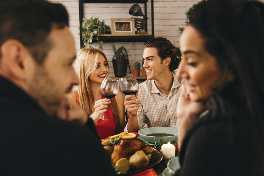 Couple showing subtle affection among friends, modeling quiet strength in marriage.
