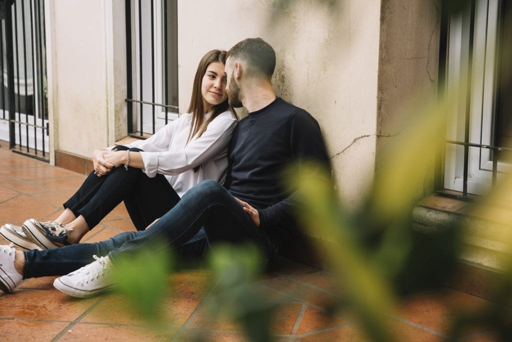 Spouses holding hands and talking intimately, valuing emotional financial investment in marriage
