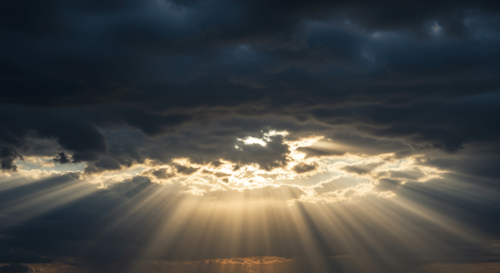 Storm clouds parting to reveal sunlight, symbolizing hope in the midst of emotional storms.