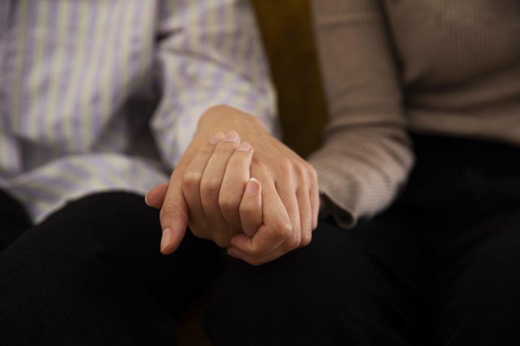 Married couple holding hands, representing intentional agreement in marriage.