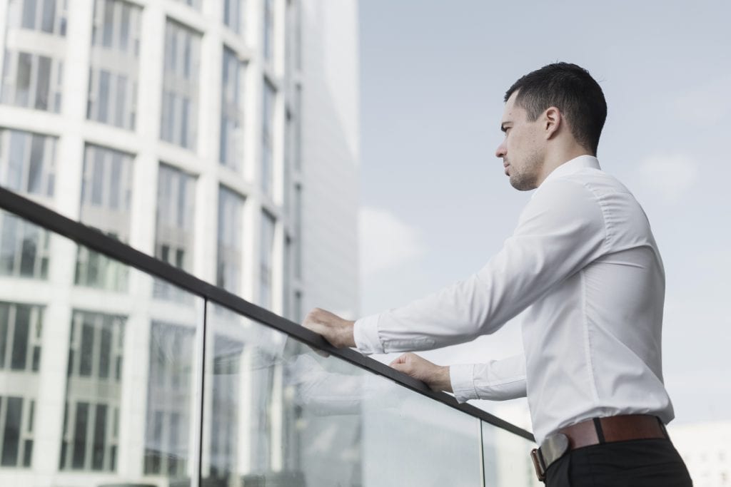Individual separated by glass, representing emotional barriers created by constant busyness.