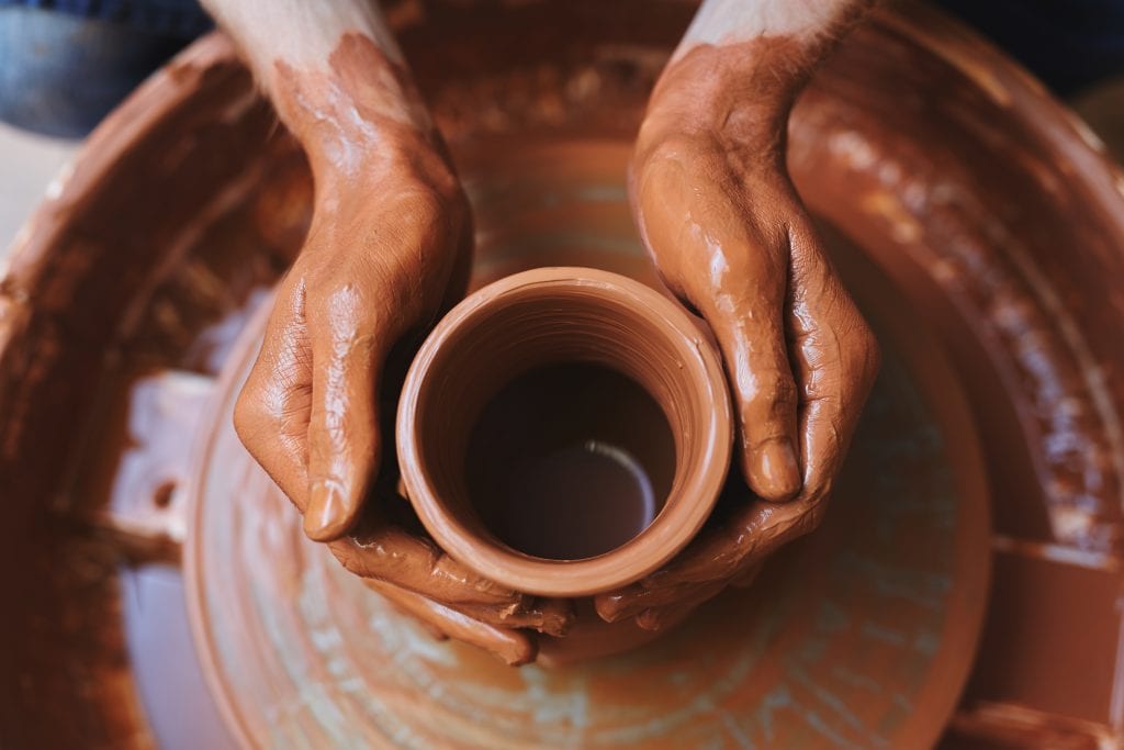 Hands molding clay on a wheel, symbolizing emotional maturity as a skill that’s shaped over time.