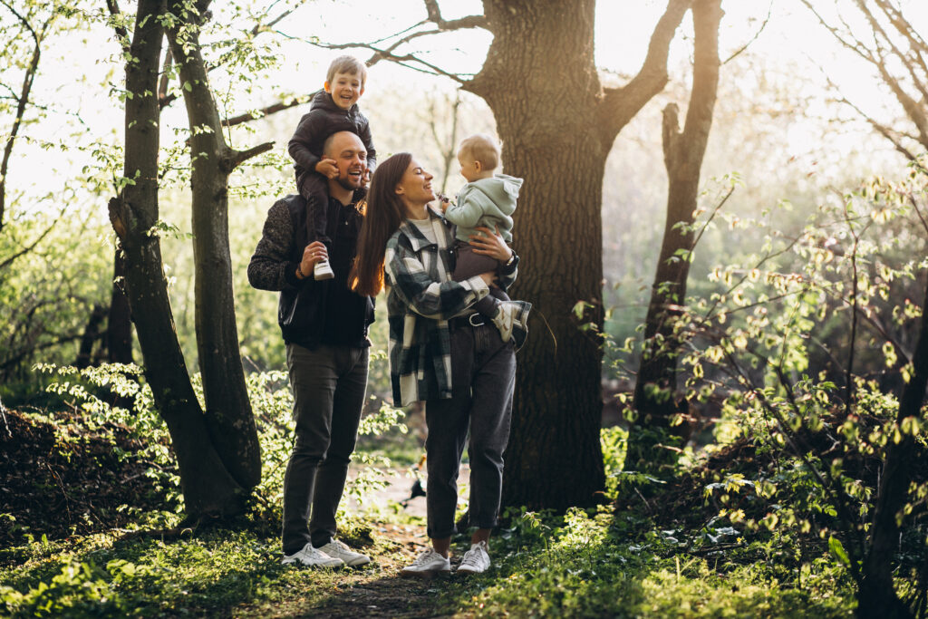 family walking on a forest path with sunlight breaking through trees representing clarity and hope