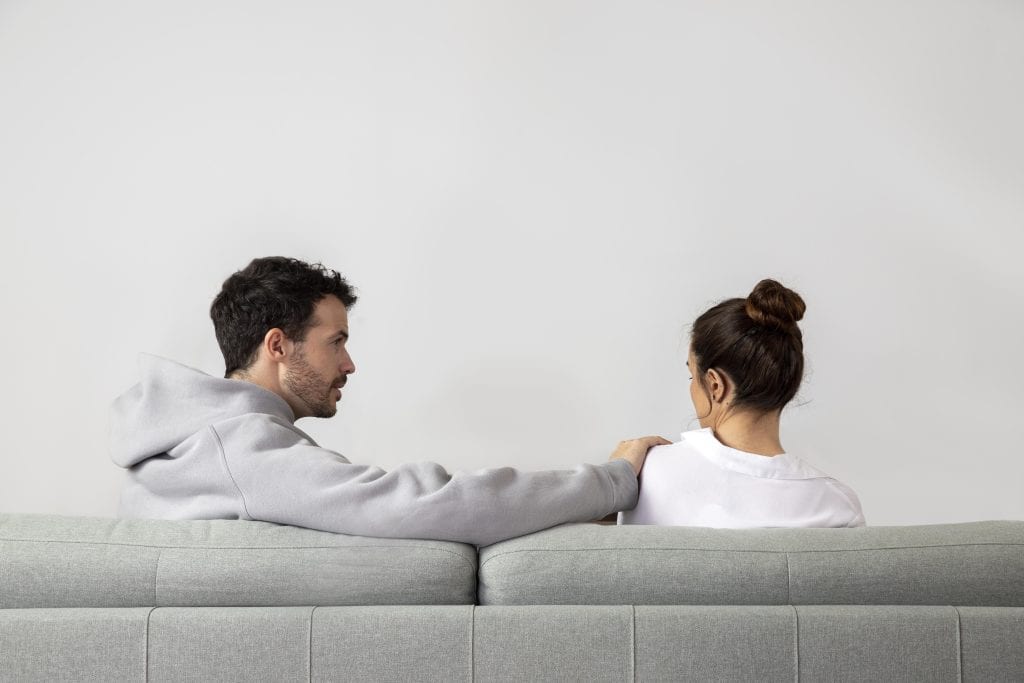 couple reaching for each other’s hands after argument representing emotional repair