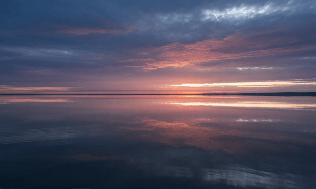 Sunrise over peaceful water, representing renewal and freedom after forgiveness in marriage.