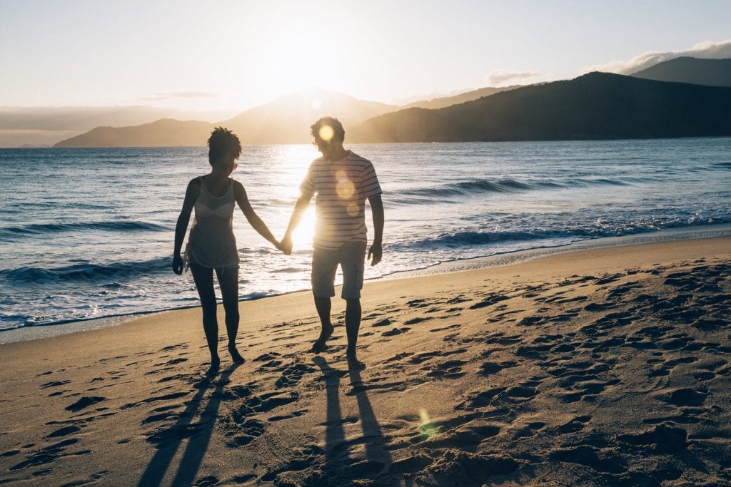 Couple walking on a beach showing the peace of early connection.