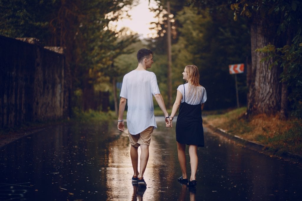 Couple walking in light rain symbolizing preparedness and togetherness.