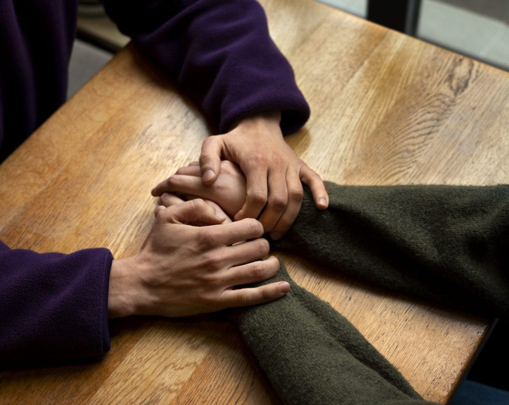 Couple reaching hands to symbolize effort and intentionality.
