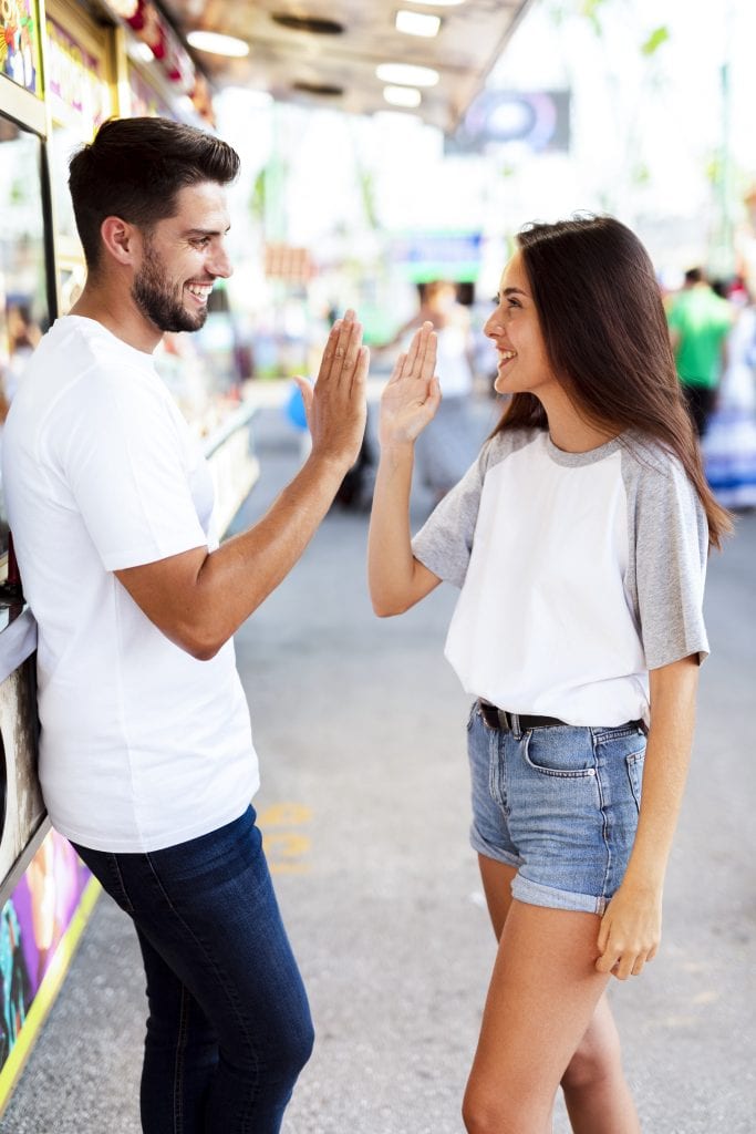 Married couple celebrating their first From Roommates to Teammates weekly check-in with a lighthearted high-five