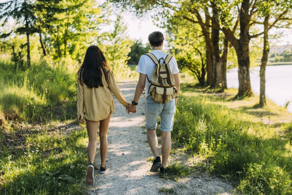 Married couple walking together through a forest trail, symbolizing slow but steady progress in marriage